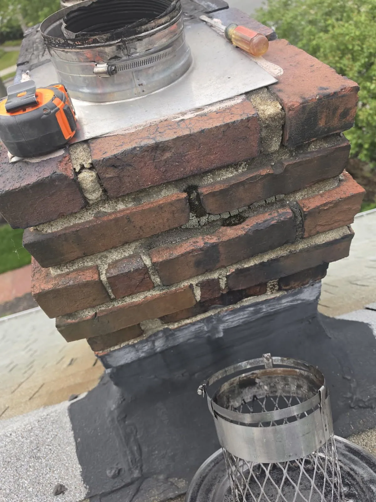Chimney cleaning equipment on brick chimney with tools and inspection caps